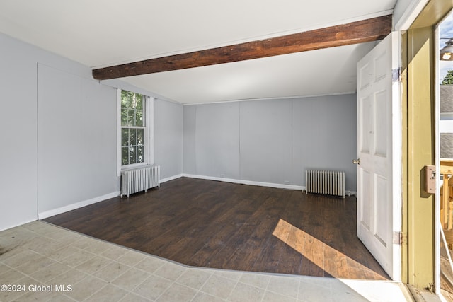 empty room with beamed ceiling, radiator heating unit, and dark hardwood / wood-style flooring