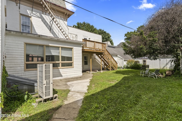 back of house featuring a deck and a lawn