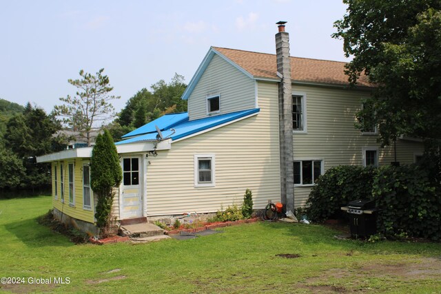 back of house with a lawn