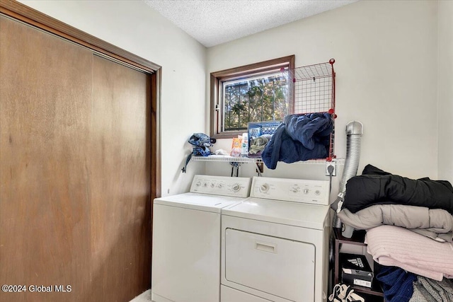 laundry area with washer and dryer and a textured ceiling