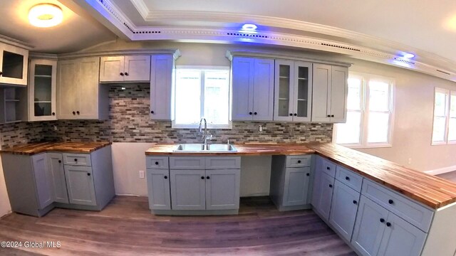 kitchen with sink, butcher block counters, gray cabinetry, tasteful backsplash, and wood-type flooring