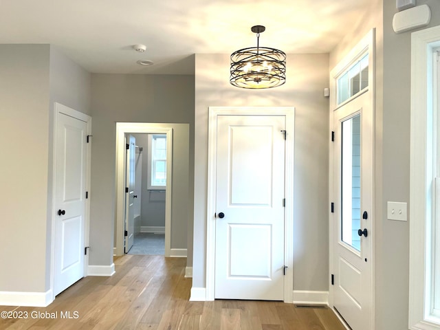 entrance foyer with an inviting chandelier and light hardwood / wood-style flooring