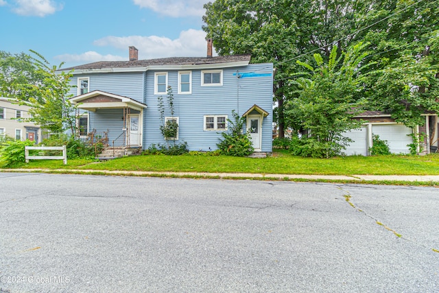 view of front of home with a garage and a front lawn