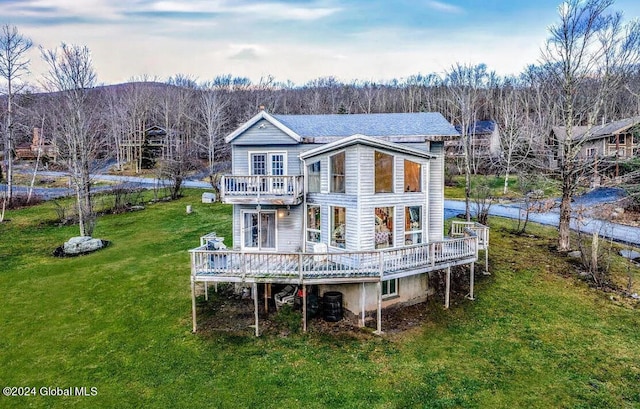 back of property featuring a balcony, central air condition unit, a deck, and a lawn