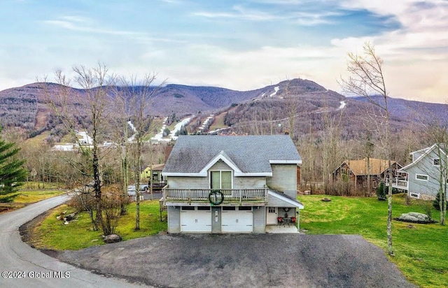 view of front facade with a front lawn, a mountain view, and a garage