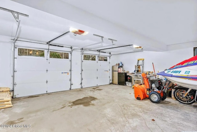 garage featuring stainless steel refrigerator and a garage door opener