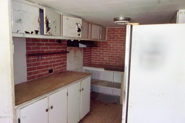 kitchen featuring white cabinetry and white refrigerator