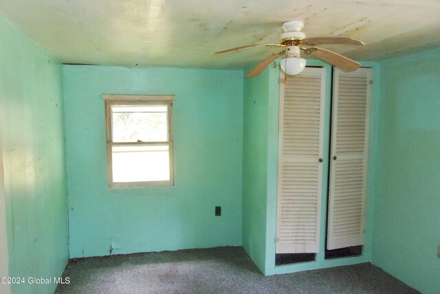 empty room with ceiling fan and carpet flooring