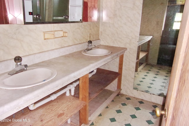 bathroom with tile walls, sink, and backsplash