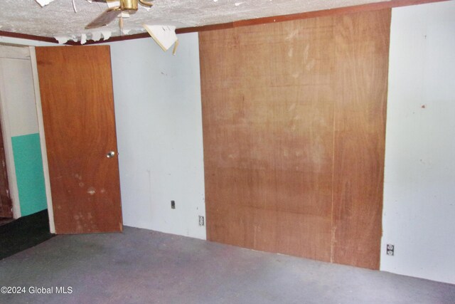 unfurnished bedroom featuring a textured ceiling and ceiling fan