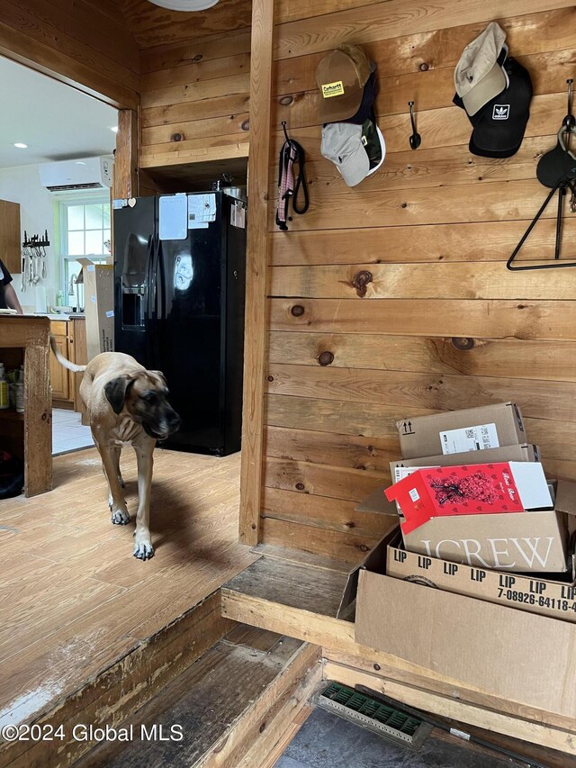 interior space featuring a wall mounted AC and black fridge