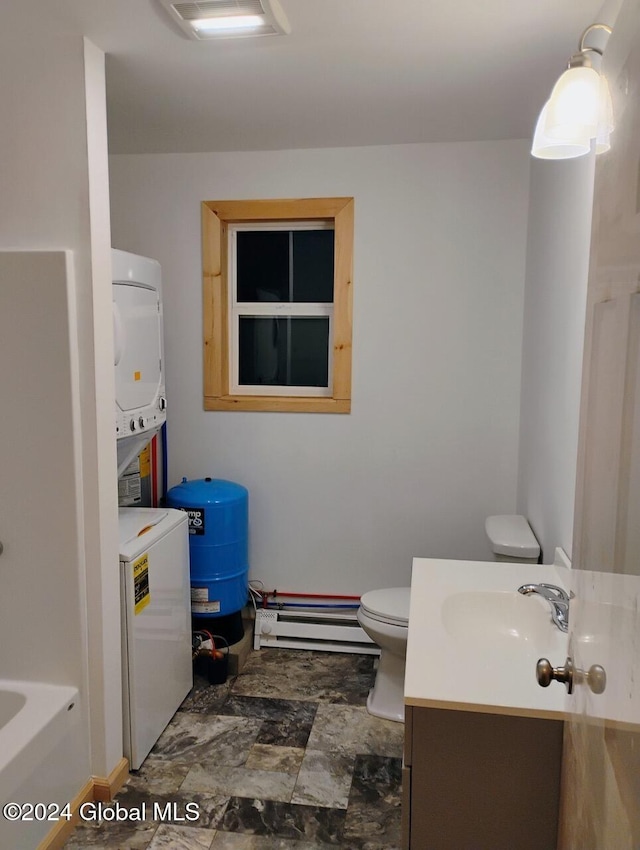 bathroom featuring baseboard heating, a tub to relax in, vanity, and toilet