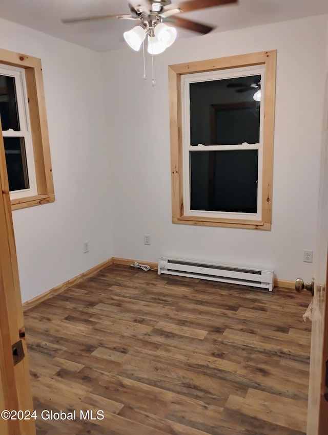 empty room with ceiling fan, a baseboard radiator, and hardwood / wood-style flooring