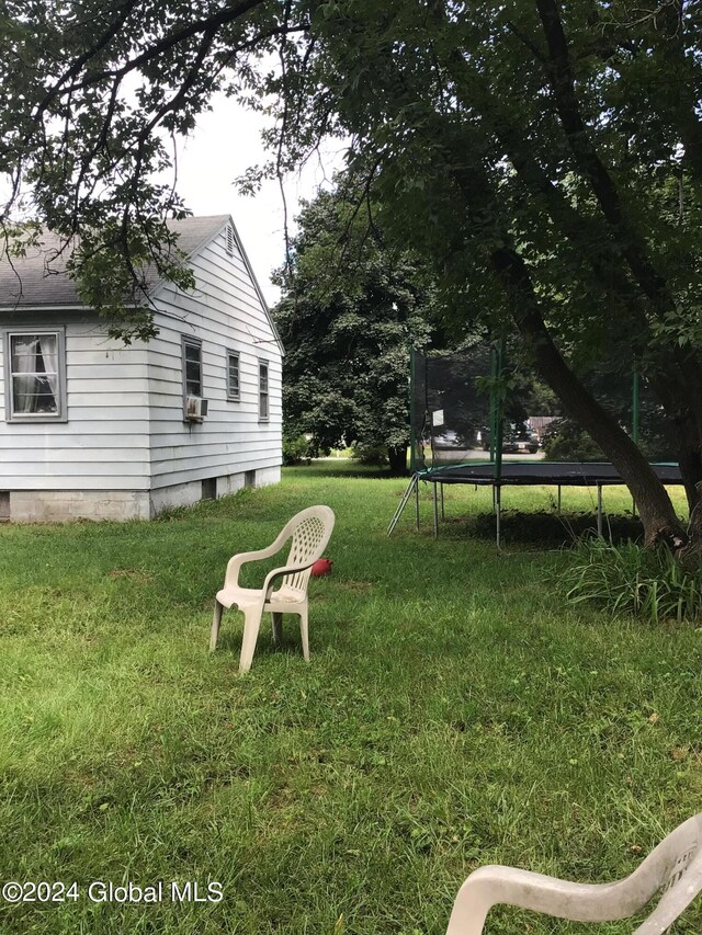 view of yard featuring a trampoline and cooling unit