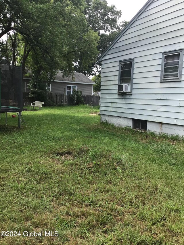 view of yard featuring a trampoline and cooling unit