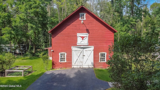 view of barn with a garden and a yard