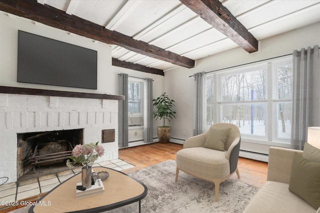 living room featuring beam ceiling, a brick fireplace, a baseboard heating unit, and wood finished floors