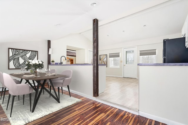 dining area with vaulted ceiling with beams, baseboards, and wood finished floors