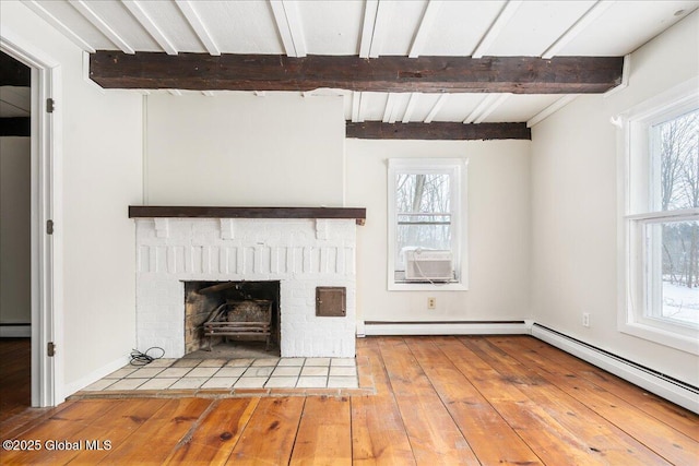 unfurnished living room with hardwood / wood-style flooring, beamed ceiling, a fireplace, and a baseboard radiator