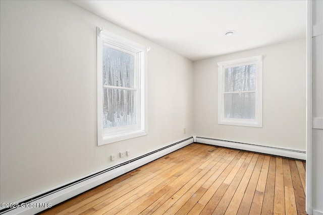 unfurnished room with light wood-style floors and a baseboard radiator