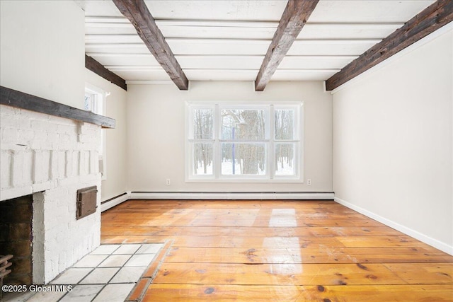 interior space with a baseboard heating unit, beam ceiling, light wood-style floors, and a brick fireplace