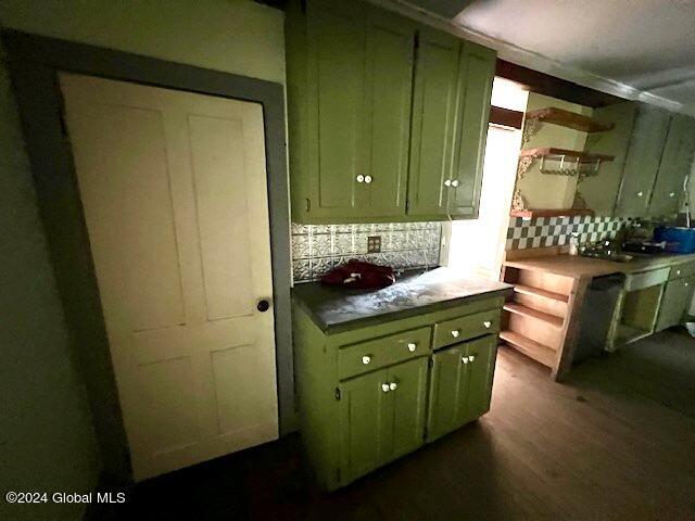 kitchen with green cabinetry, decorative backsplash, and dark hardwood / wood-style floors