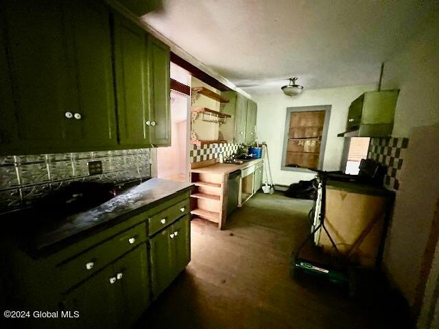 kitchen featuring green cabinets and tasteful backsplash