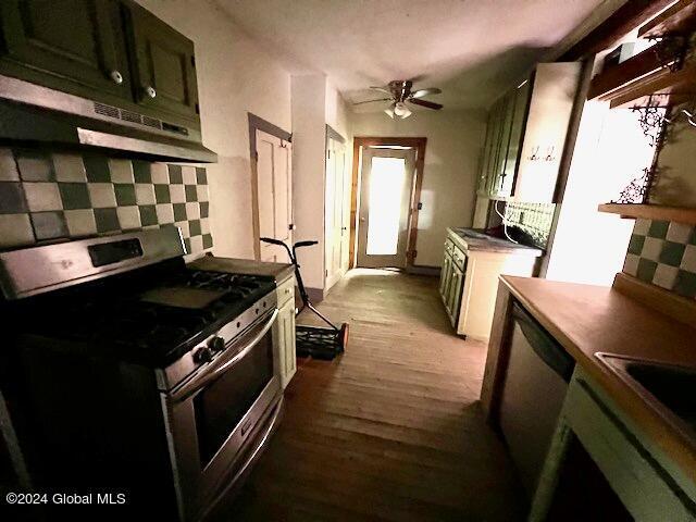 kitchen featuring backsplash, appliances with stainless steel finishes, green cabinets, light hardwood / wood-style floors, and ceiling fan