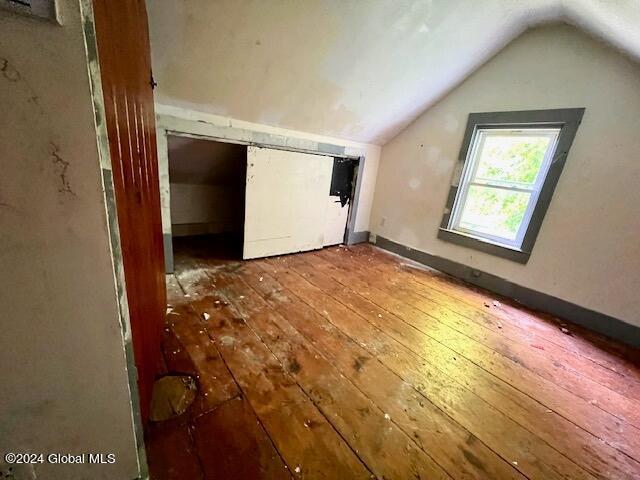 additional living space featuring hardwood / wood-style flooring and vaulted ceiling