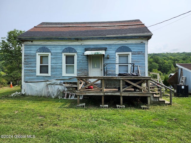 back of house with a wooden deck and a yard