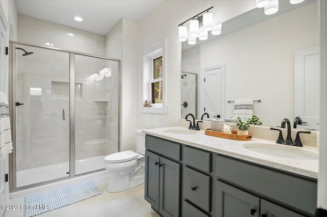 bathroom with an inviting chandelier, tile patterned flooring, a shower with shower door, double sink vanity, and toilet