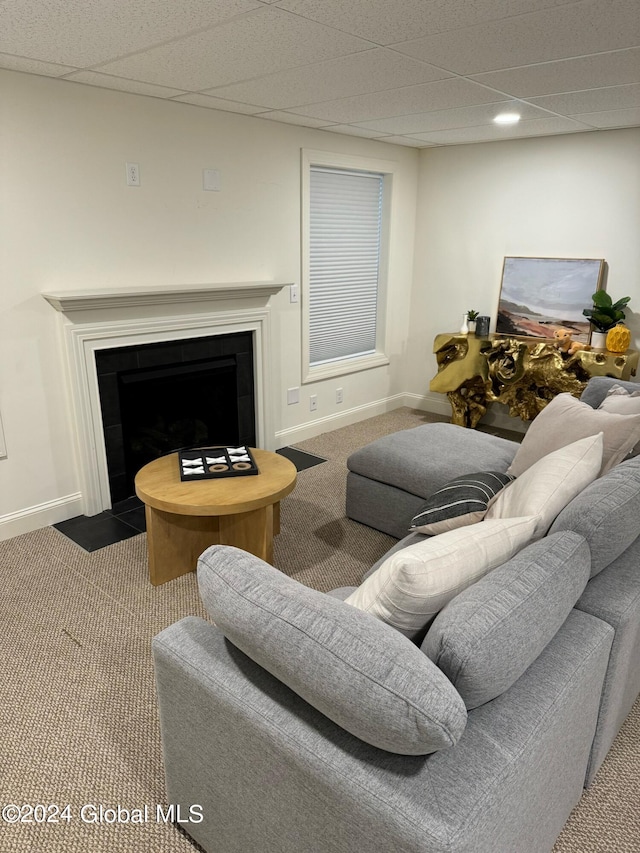 living room featuring carpet floors and a drop ceiling