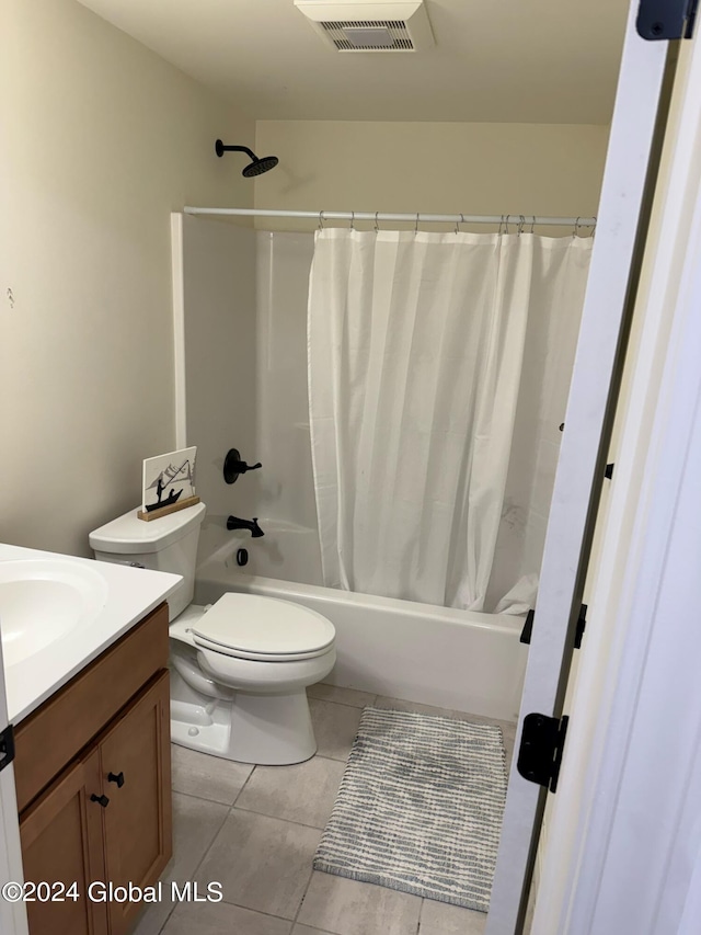 full bathroom with tile patterned flooring, shower / bath combo with shower curtain, vanity, and toilet