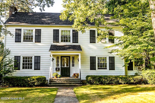 colonial-style house featuring a front yard