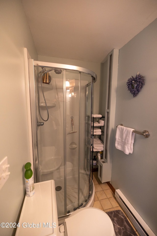 bathroom with baseboard heating, a shower with door, toilet, and tile patterned floors