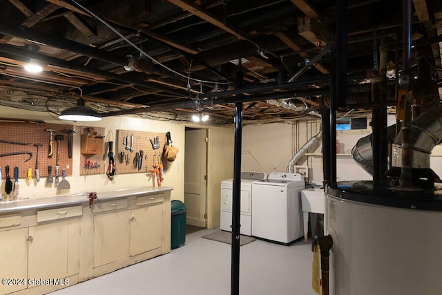 basement with gas water heater, a workshop area, sink, and independent washer and dryer