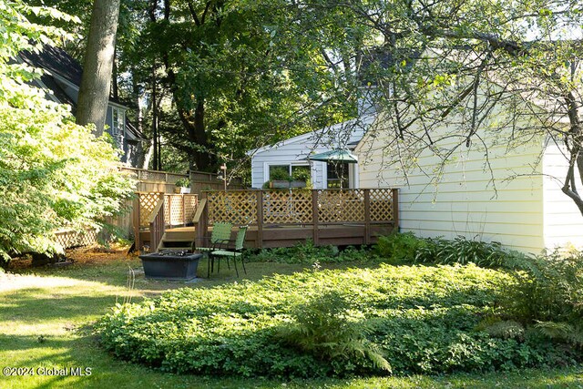 view of yard featuring a deck and a fire pit