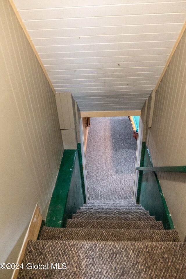 stairs with wooden walls and carpet