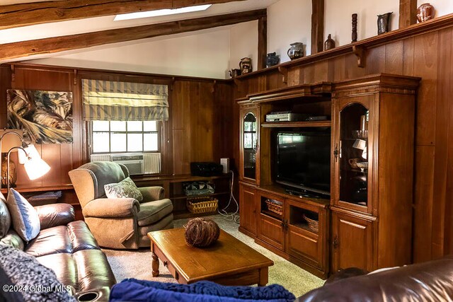 living room with vaulted ceiling with beams, wood walls, and carpet