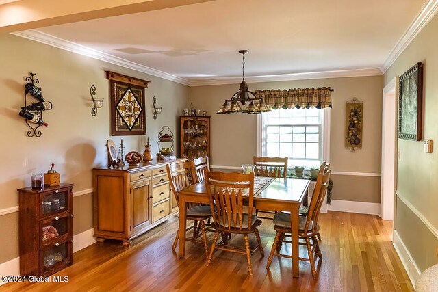 dining room featuring ornamental molding, a chandelier, and light hardwood / wood-style floors