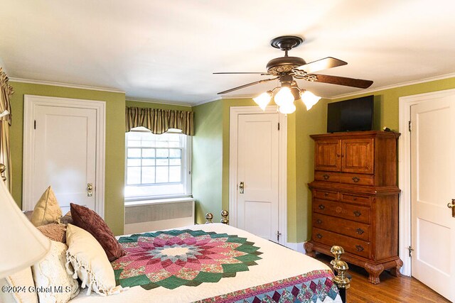 bedroom featuring ceiling fan, ornamental molding, radiator, and hardwood / wood-style floors