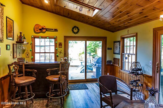 bar with wood ceiling, a wealth of natural light, vaulted ceiling, and wood-type flooring