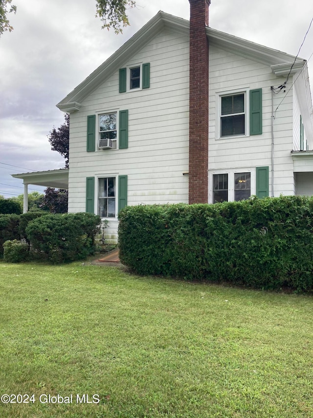 view of side of home with a lawn and cooling unit