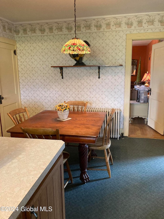 dining area with dark colored carpet and crown molding