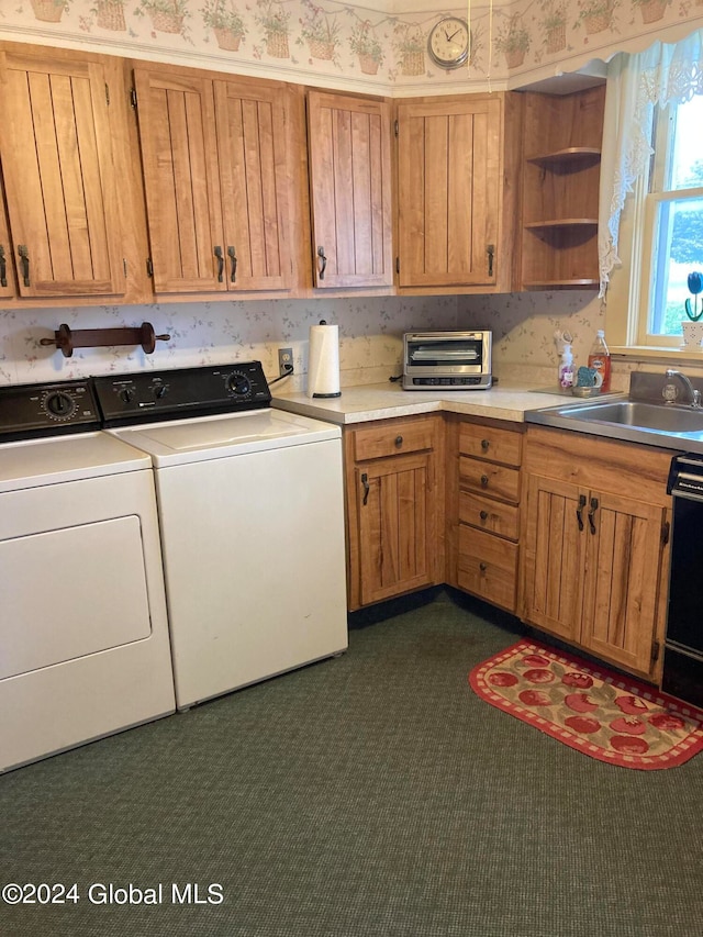 kitchen featuring sink, washing machine and dryer, black dishwasher, and dark carpet