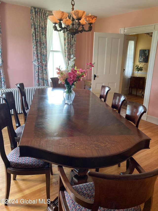 dining area featuring light hardwood / wood-style floors and a chandelier