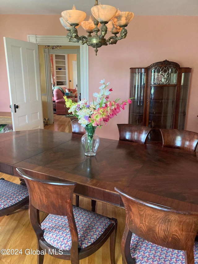 dining area featuring light hardwood / wood-style flooring and a chandelier