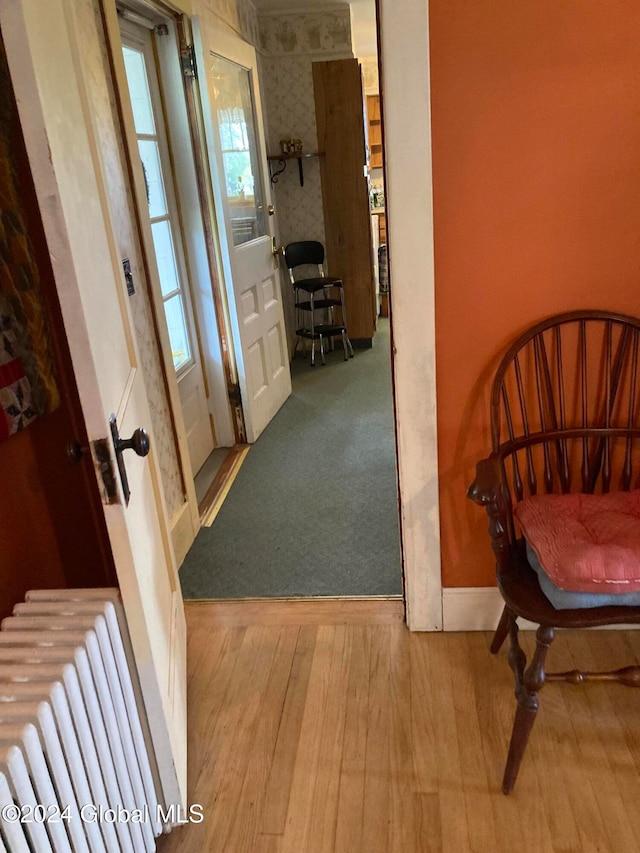 hallway with light hardwood / wood-style flooring and radiator