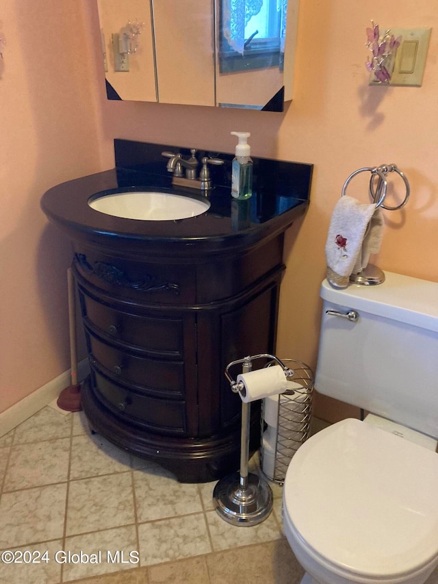 bathroom with tile patterned flooring, vanity, and toilet