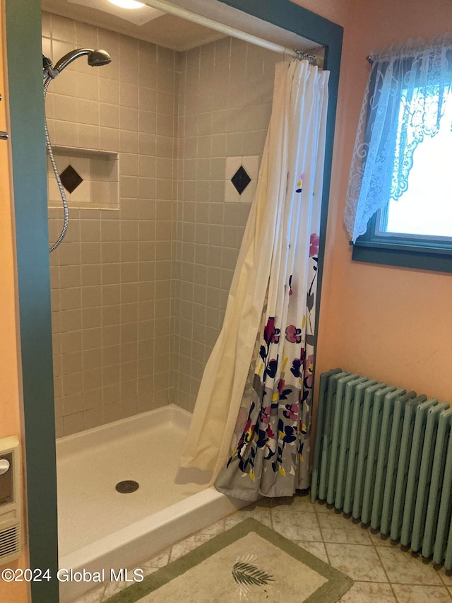 bathroom featuring radiator heating unit, walk in shower, and tile patterned floors